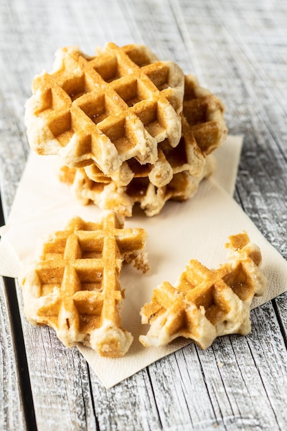tasty sweet waffles on white wooden table