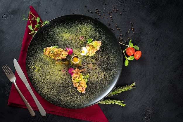 Tasty tartar salad on black background