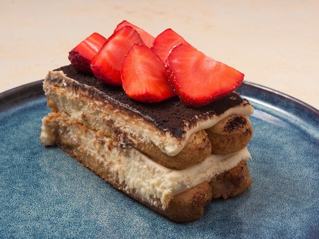 Tasty tiramisu decorated with strawberries in the restaurant Close up