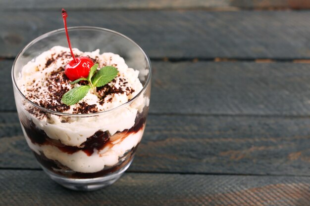 Tasty tiramisu dessert in glass on wooden background