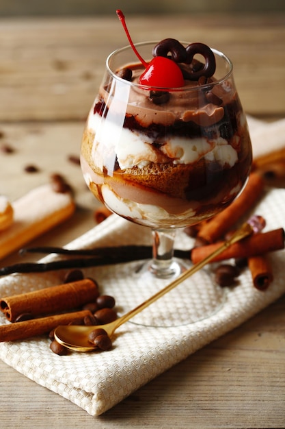 Tasty tiramisu dessert in glass on wooden background