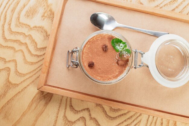 Tasty tiramisu dessert on wooden tray close up