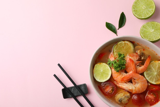 Tasty Tom yum soup on pink background