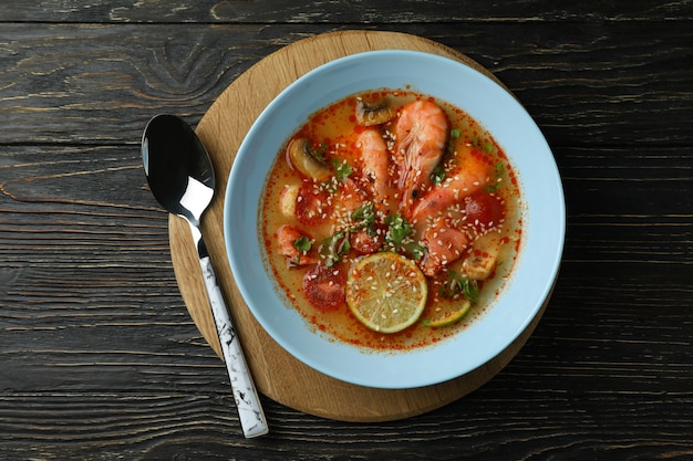 Tasty Tom yum soup on wooden background