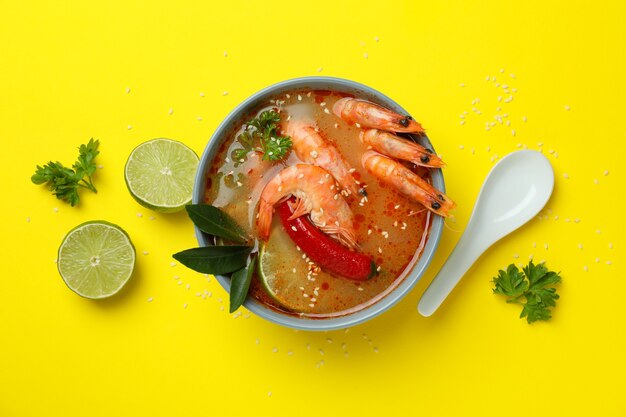 Tasty Tom yum soup on yellow background