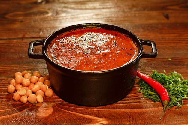 Una gustosa zuppa di pomodoro in una ciotola di metallo servita in un ristorante armeno decorato con ceci marinati