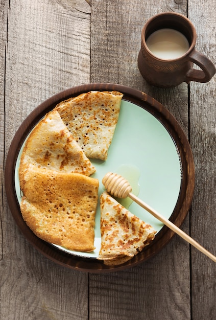 Prima colazione russa tradizionale saporita dei pancake con miele sul piatto.