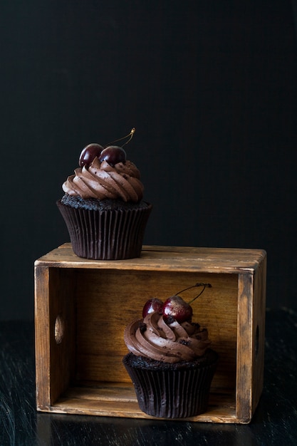 A tasty treat: frosted cupcakes with cherries on top.