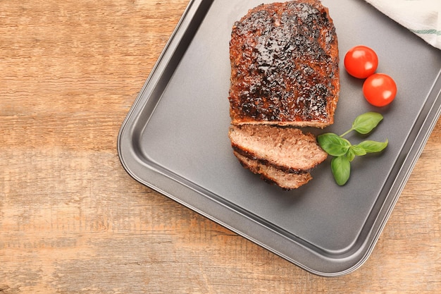 Tasty turkey meatloaf with basil and tomatoes on baking tray