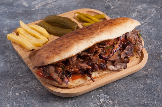 Tasty Turkish Doner with veal in bread with French fries pickles