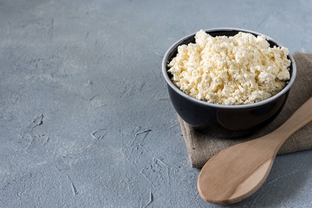 tasty useful fresh cottage cheese, cottage cheese. Homemade white cheese crumbles in a porcelain bowl