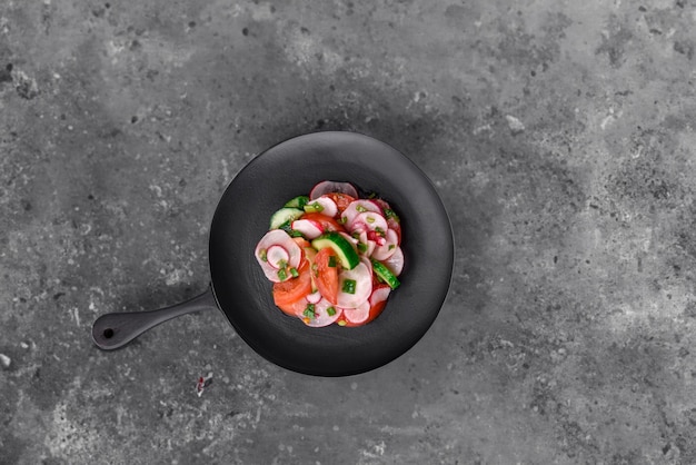 Tasty vegan salad with tomatoes cucumbers and radishes