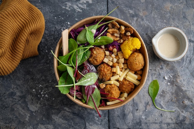 Tasty vegan vegetarian salad with chickpea, falafel and leaves served on plate.