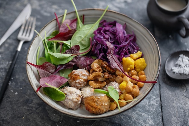 Photo tasty vegan vegetarian salad with chickpea, falafel and leaves served on plate.