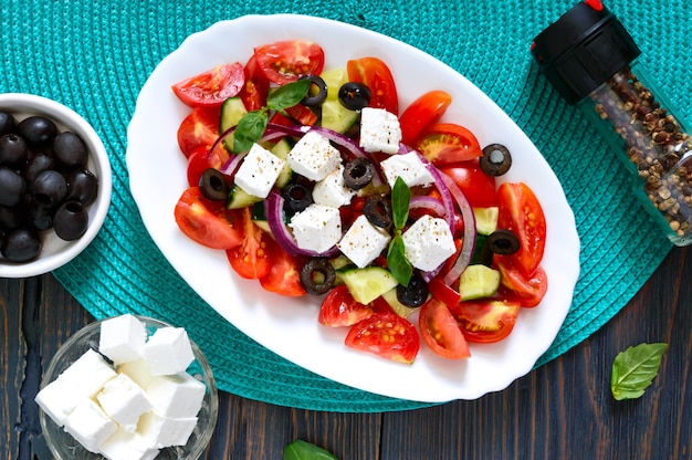 Tasty vegetarian salad of tomato, cucumber, red onion, and black olives