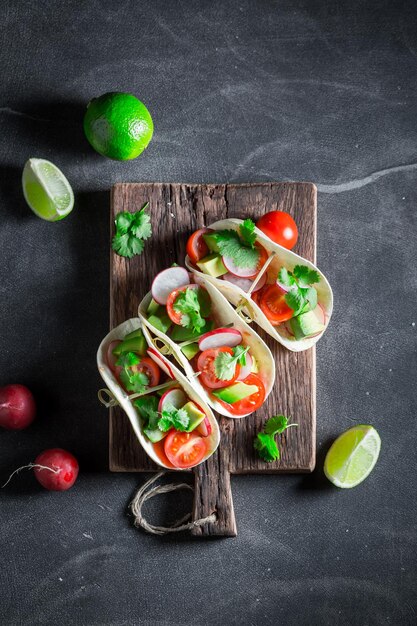 Tasty and vegetarian tacos made of tomatoes avocado and hebrs