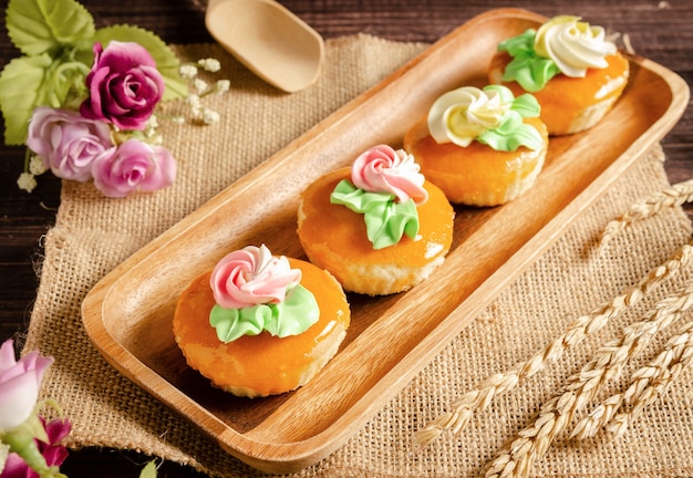 tasty vintage cupcakes on wooden tray with flowers