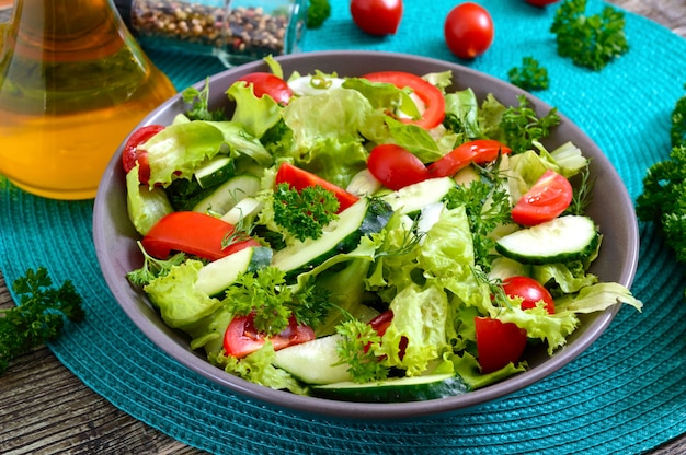 Tasty vitamin dietary salad with fresh cucumbers, tomatoes, greens. Salad from organic vegetables.