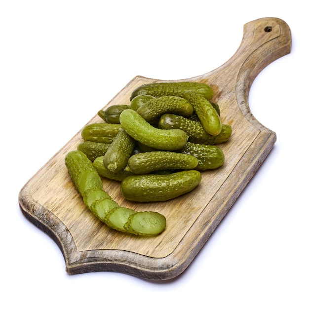 Tasty whole green cornichons on wooden serving board isolated on a white background