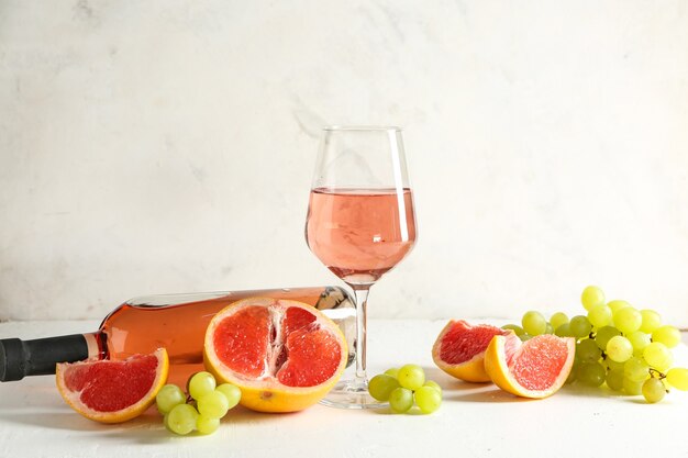 Vino gustoso con frutta fresca sul tavolo bianco