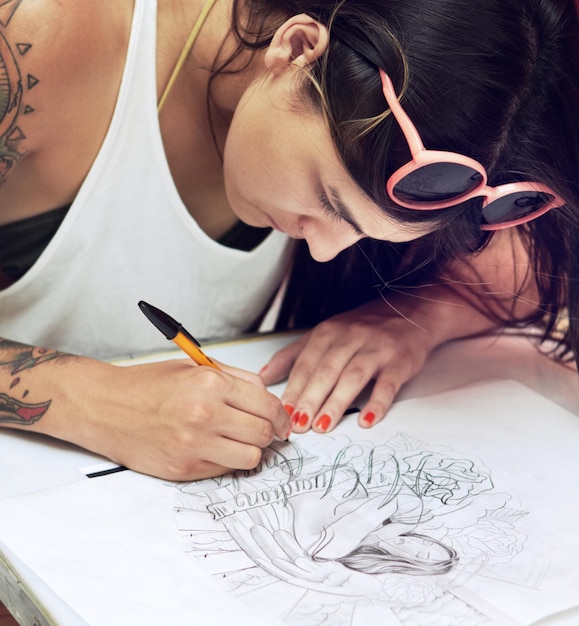 Tatoeëerder aan het werk een meesterwerk is geboren Shot van een jonge tatoeëerder die een tekening schetst