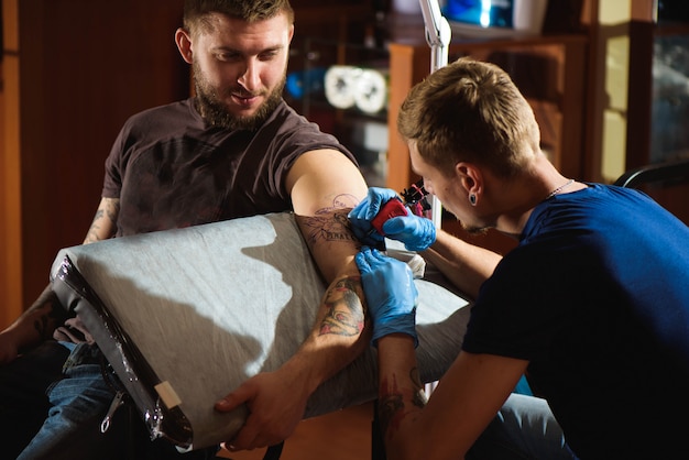 Foto tatoeëerder maakt een tatoeage.