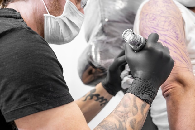 Tatoeëerder maakt tatoeage in de studio hoge kwaliteit fotografie