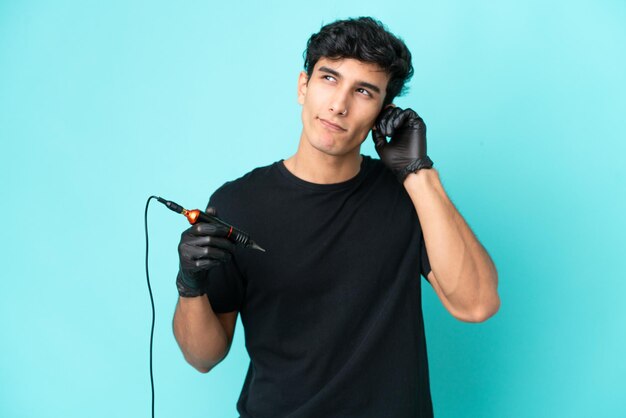 Tattoo artist Argentinian man isolated on blue background frustrated and covering ears