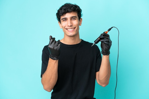 Tattoo artist Argentinian man isolated on blue background making money gesture