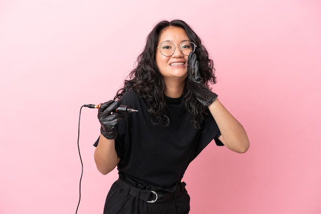 Tattoo artist asian woman isolated on pink background shouting with mouth wide open