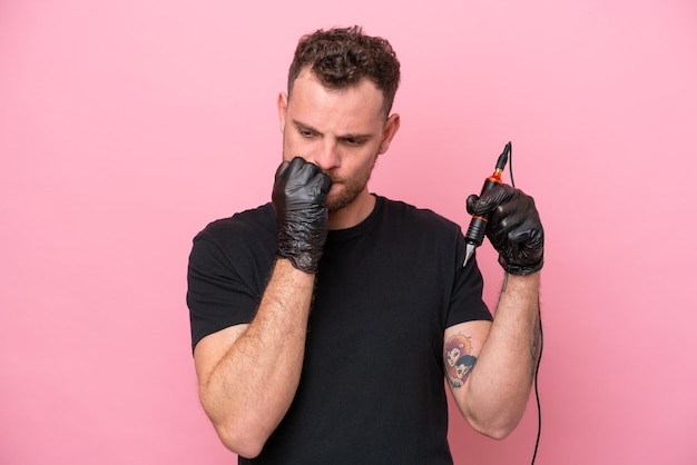 Tattoo artist brazilian man isolated on pink background having doubts