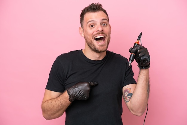 Tattoo artist brazilian man isolated on pink background with surprise facial expression