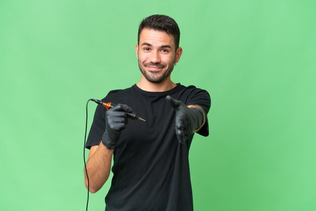 Tattoo artist caucasian man over isolated background shaking hands for closing a good deal