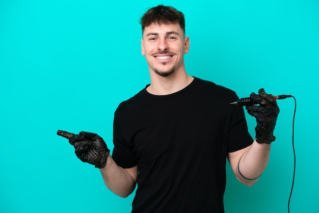 Tattoo artist caucasian man isolated on blue background pointing finger to the side