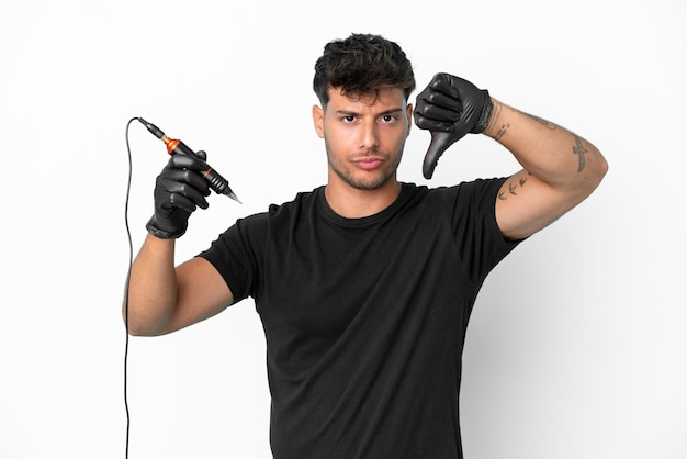 Tattoo artist caucasian man isolated on white background showing thumb down with negative expression