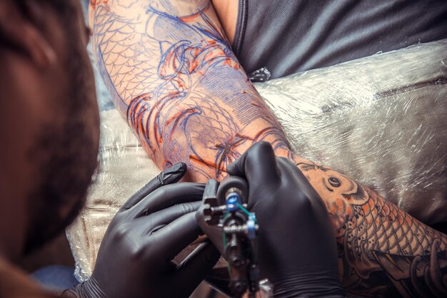 Tattoo Artist Doing Tattoo In Tattoo Parlour