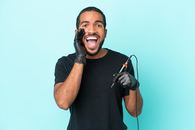 Tattoo artist Ecuadorian man isolated on blue background shouting with mouth wide open