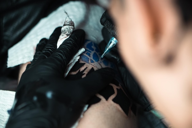 A tattoo artist is drawing a tattoo on a person's arm.