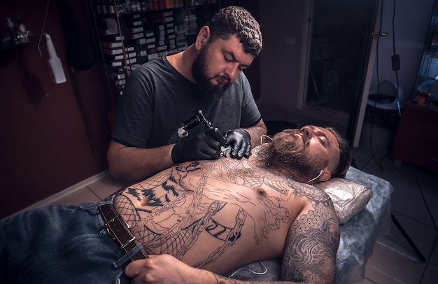 Tattoo artist makes tattoo pictures in tattoo studio.