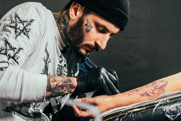 Foto un tatuatore fa un tatuaggio in un salone