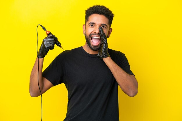 Tattoo artist man brazilian man isolated on yellow background shouting with mouth wide open