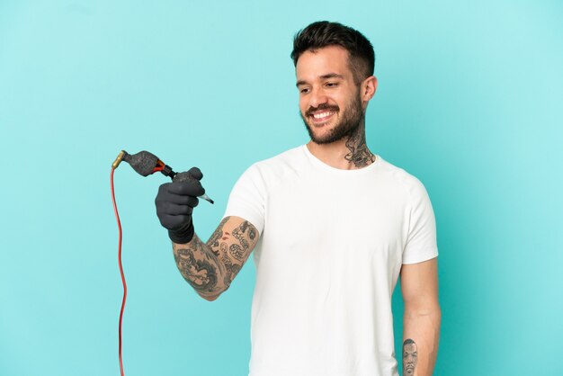 Татуировщик человек на изолированном синем фоне со счастливым выражением лица