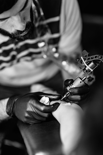 Tattoo artist tattooing young woman