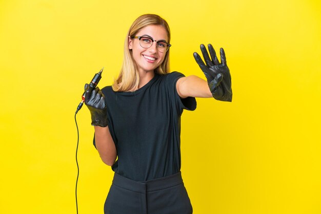 Tattoo artist uruguayan woman isolated on yellow background happy and counting four with fingers