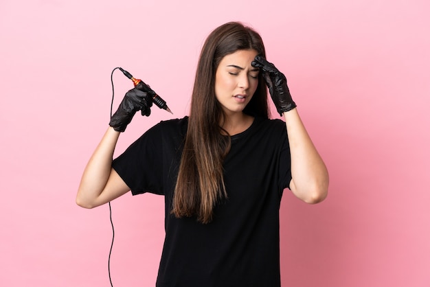 Tattoo artist woman isolated on pink background with headache