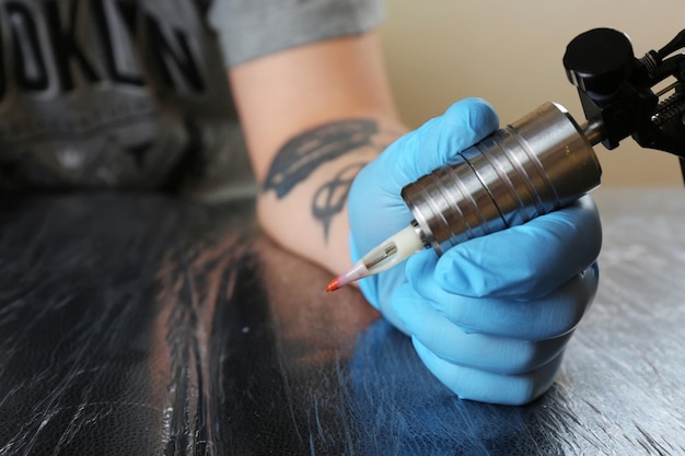 Tattoo artist at work close up