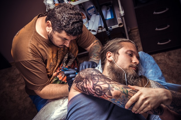 Tattoo artist working tattooing in tattoo studio