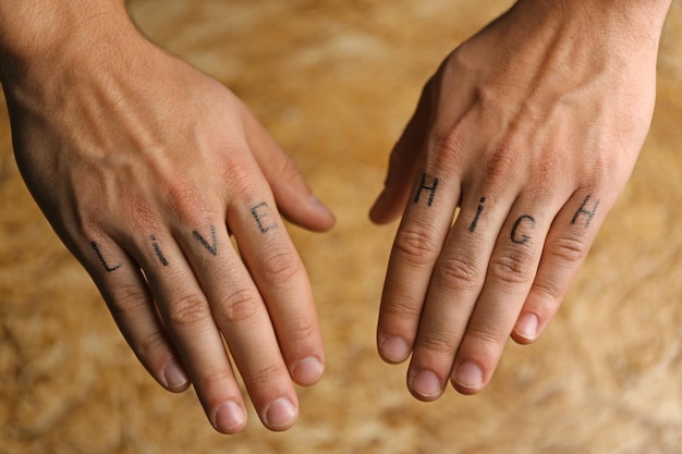 Tattoo inscriptions on male fingers drawn with marker