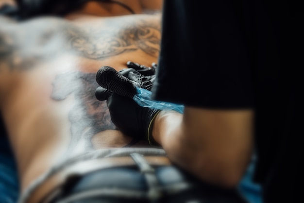 Foto tattoo kunstenaar tekenen van kunst op het lichaam