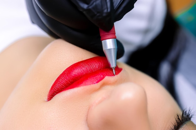 タトゥーマスターは、ペンでモデルの唇にスケッチを描きます